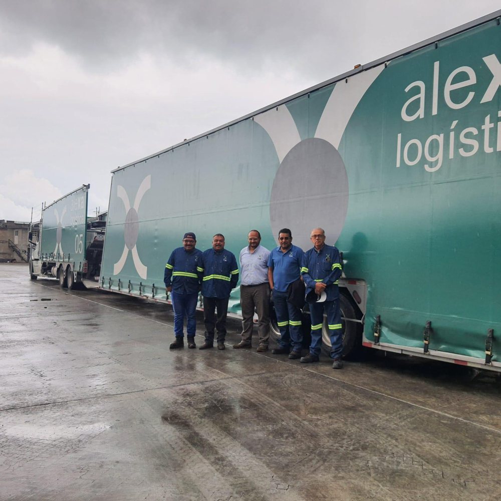 Equipo junto a una unidad de transporte durante una visita de trabajo
